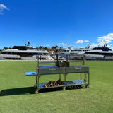 Open Fire Grill Tagwood BBQ24SS Double Argentine Santa Maria Grill 304 SS - Shared firebox - Height-adjustable grates - Interchangeable griddle -Meat hooks - Foldable side table and 6 heavy-duty swivel casters - PRE-ORDER